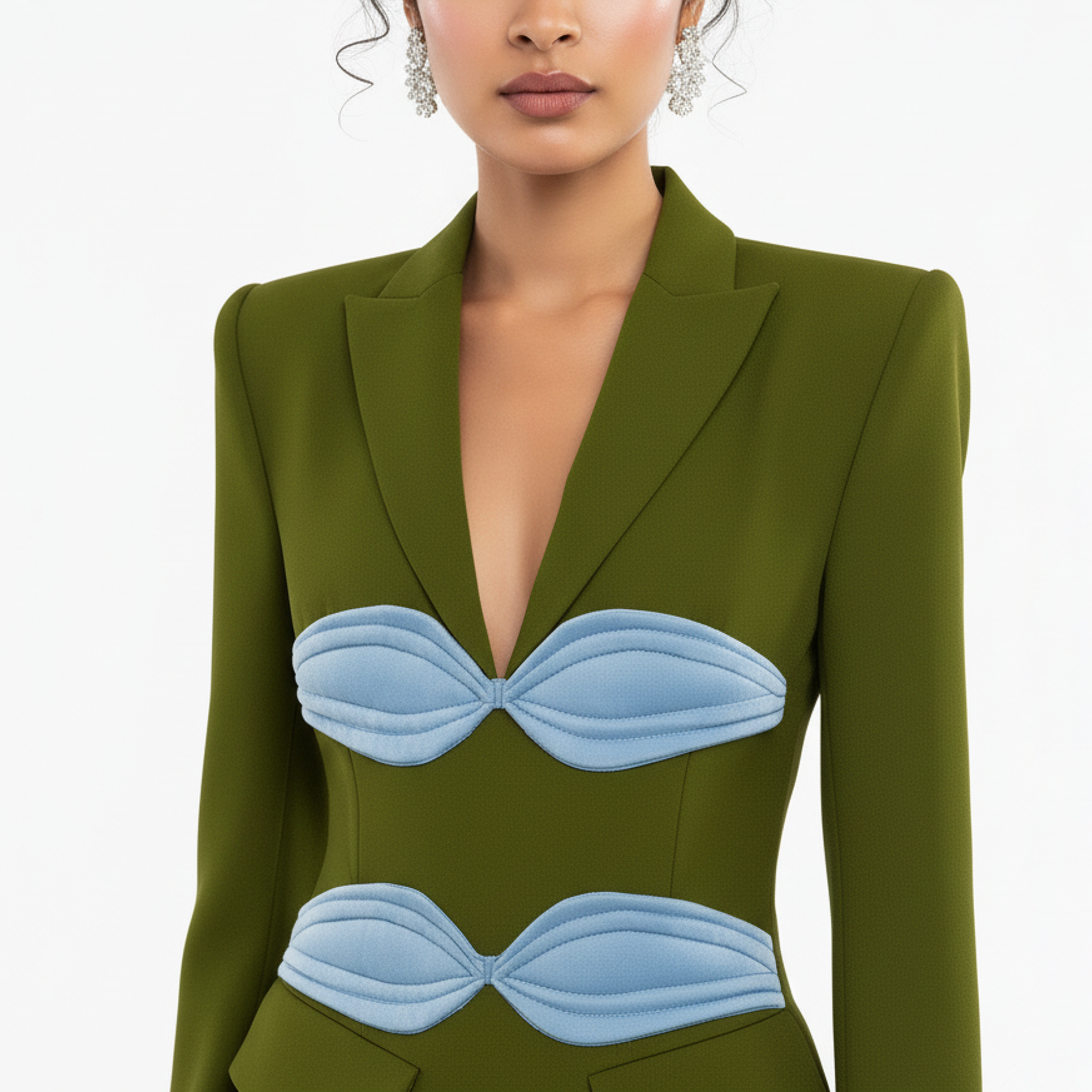 Green blazer with blue bandeau details worn by a model on a white background