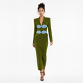 Woman wearing a green dress with blue accents on a white background