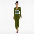 Woman wearing a green dress with blue accents on a white background