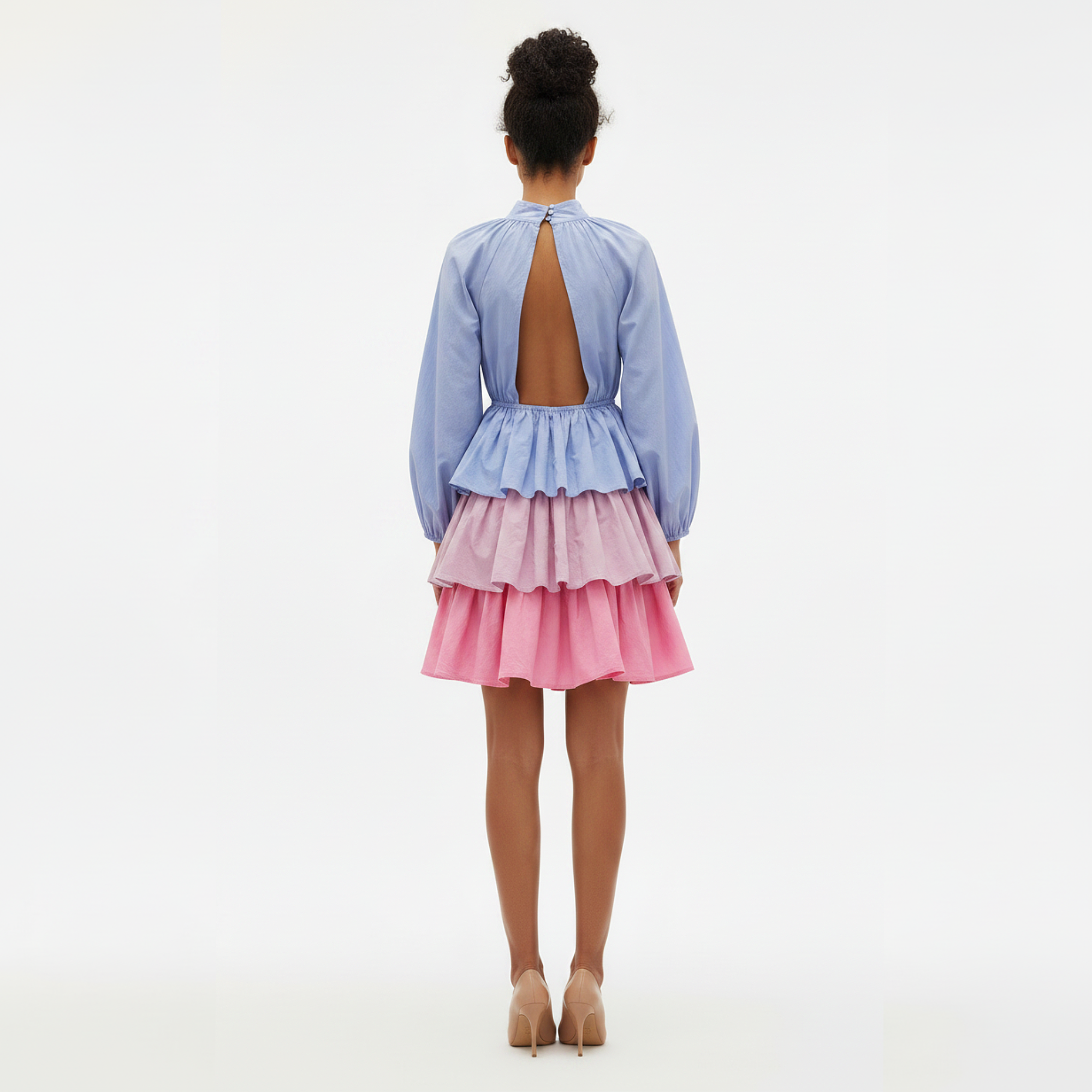 Woman wearing a blue and pink dress with an open back on a white background