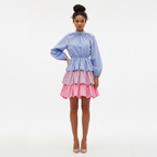 Woman wearing a two-tone dress with a blue top and pink skirt on a white background