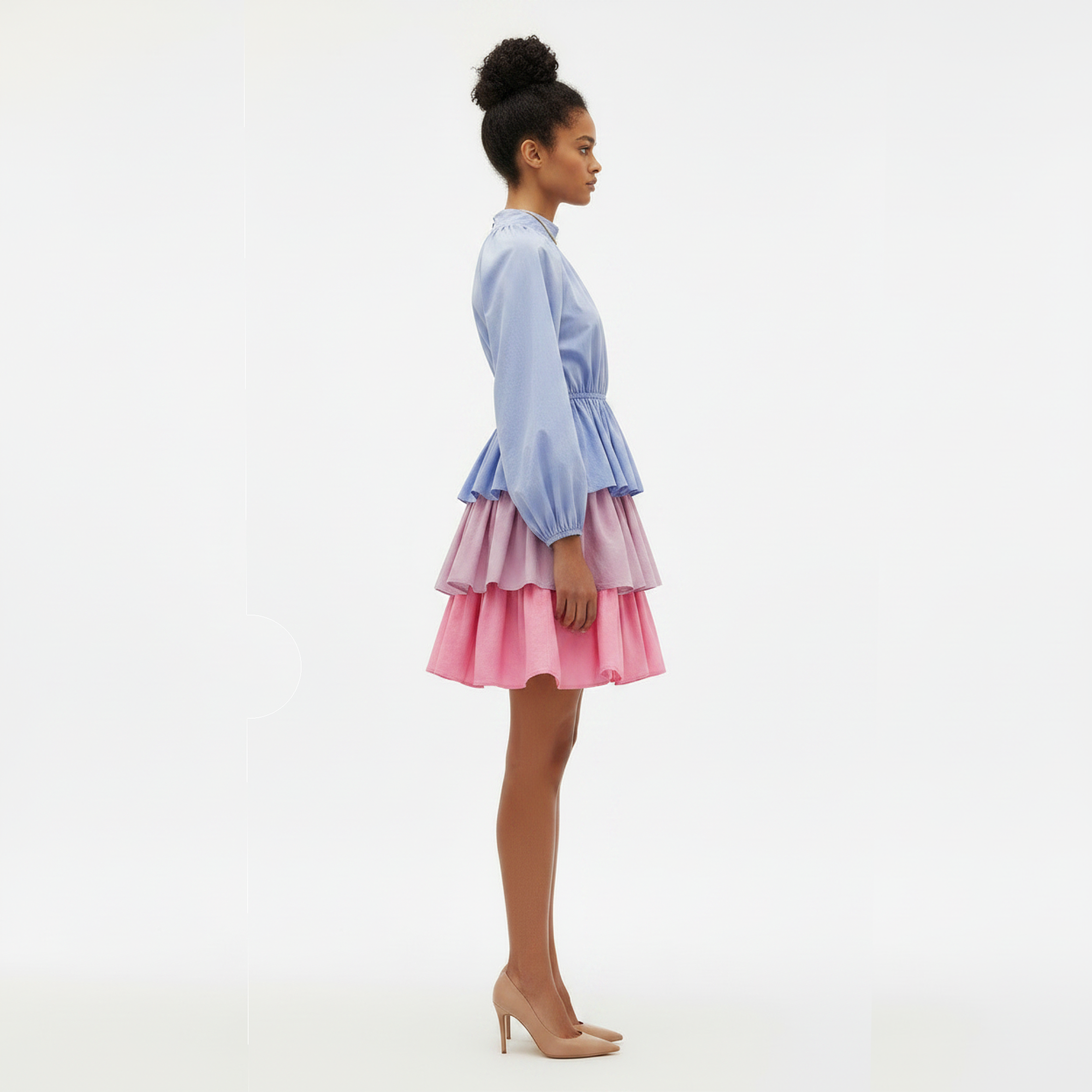 Woman wearing a light blue top and pink skirt on a white background