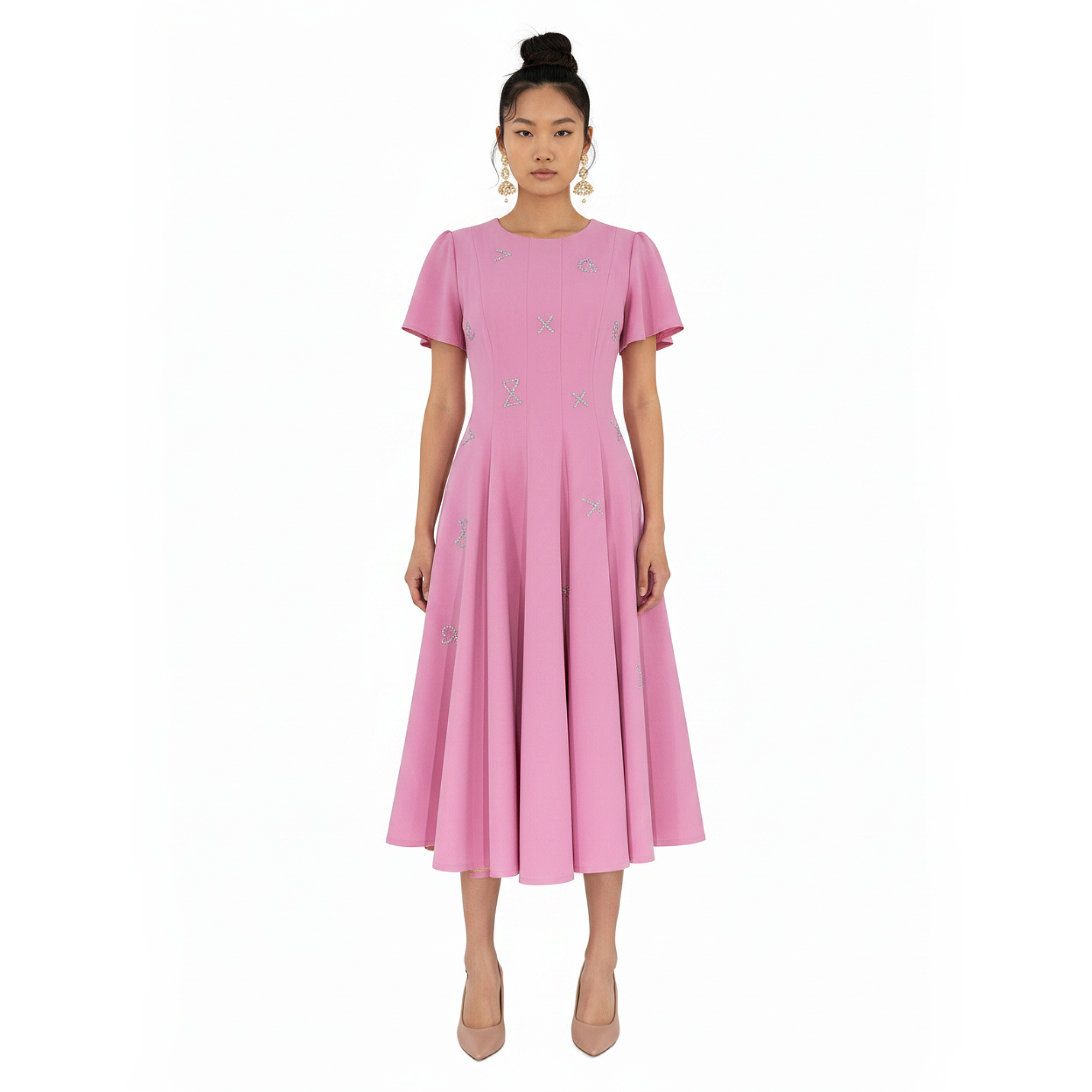Woman wearing a pink dress with a subtle pattern on a white background