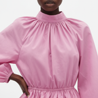 Close-up of a pink dress with long sleeves on a white background