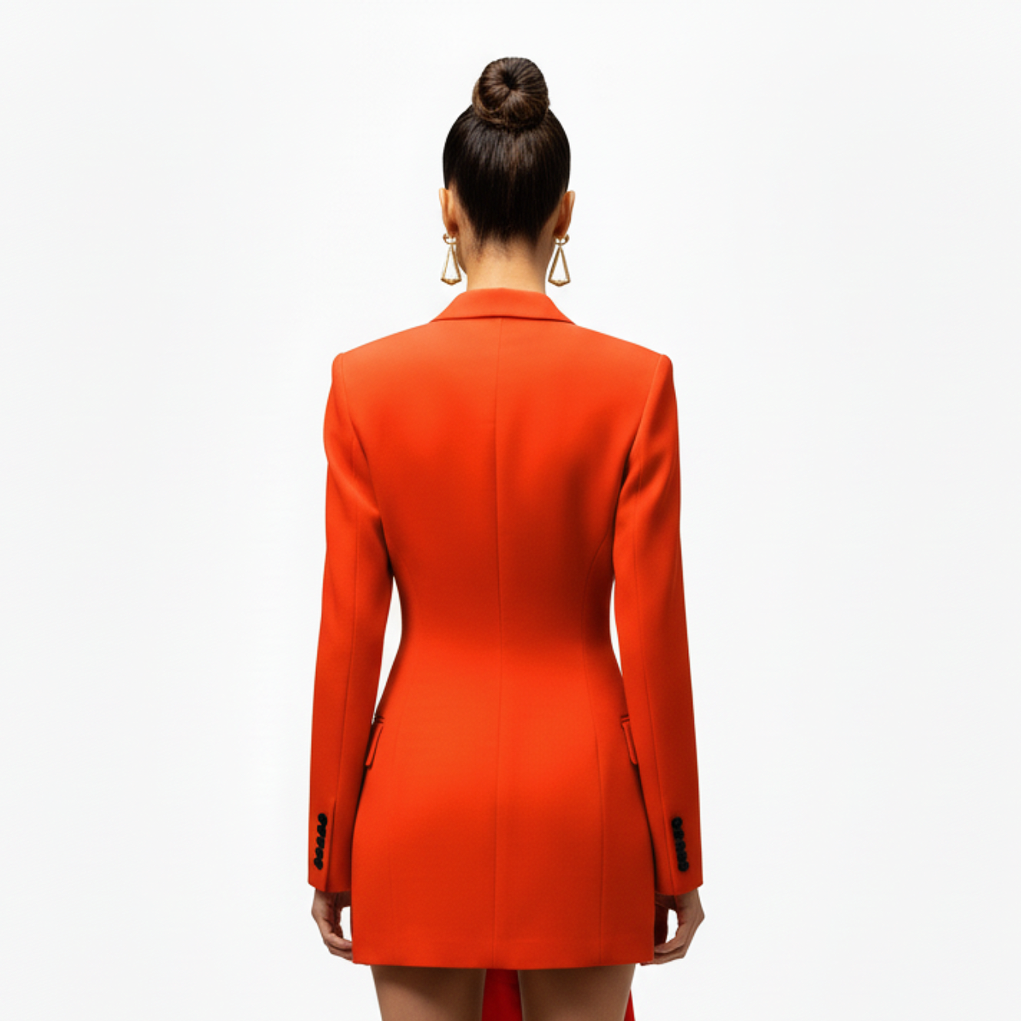 Person wearing an orange blazer dress from behind on a white background