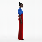 Woman wearing a blue top and red dress on a white background