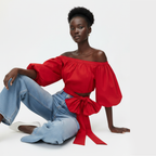 Woman wearing a red off-shoulder top with a blue jeans on a white background