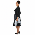 Woman wearing a black coat with white floral patterns on a white background