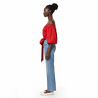 Woman wearing a red off-shoulder top with a blue jeans on a white background