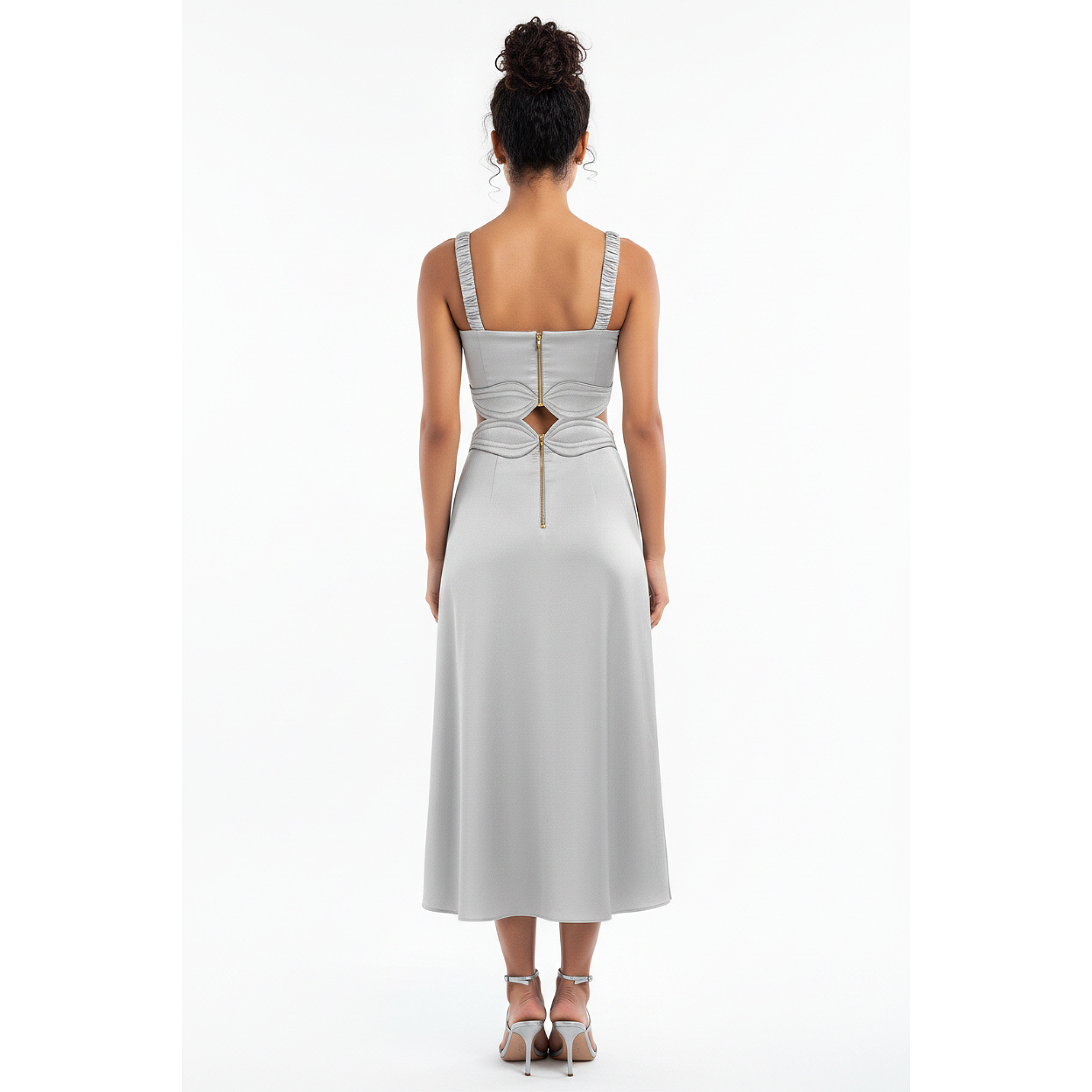 Woman wearing a light white dress with cut-out back design on a white background