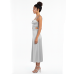 Woman wearing a silver dress with cut-out design on a white background