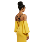 Woman wearing a yellow dress with black straps on a white background