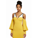 Woman wearing a yellow dress with black trim on a white background